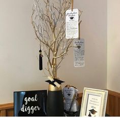 there is a small tree that has been decorated with gold branches and black ribbon on it