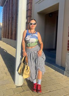 a woman standing next to a pole holding a handbag