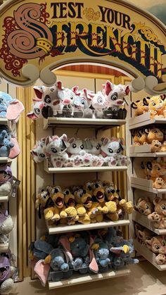 many stuffed animals are on shelves in front of a sign that says test your strength