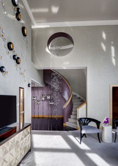 a living room filled with furniture and a spiral staircase next to a flat screen tv