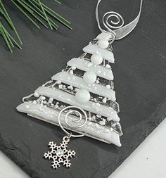 a glass christmas tree ornament on a slate board