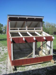 a small chicken coop in the middle of a field