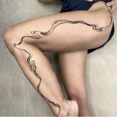 a woman's legs with tattoos on them and her leg in the shape of a wave