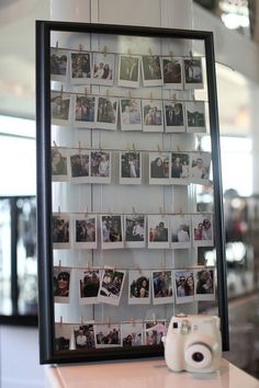 a camera sitting on top of a table next to a wall covered in pictures and photos