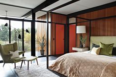 a large bed sitting in a bedroom next to a window with lots of glass doors