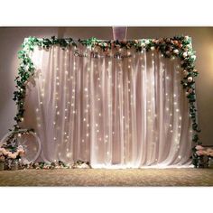 a wedding backdrop with flowers and lights