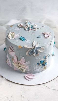 there is a cake that has been decorated with flowers and butterflies on the frosting