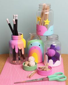 there are some crafting supplies on the table with scissors and other things in jars