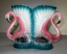 two pink and blue flamingos sitting on top of each other