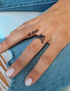 a woman's hand with a bee tattoo on her left thumb and the words be good written in black ink