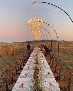 the long table is set with plates and place settings for people to sit at it