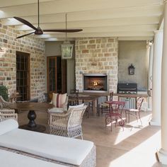 an outdoor living area with wicker furniture and fireplace