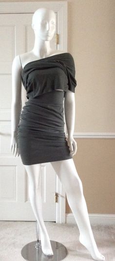 The first four photos show this garment as a top that is ruched at the hips. The next two photos show it ruched as a middy top, or extended as a tunic over the coordinating skirt (shown in a separate listing). This Smokey green tunic top is very versatile. It can be worn as a single sleeve asymmetrical dress or as a short, waist length, or hip length top. It coordinates with the skirt/dress in a separate listing. Size 8USA, but fits a USA 10 as well. Measurements:Bust - 36” Waist - 32”Hips - 34” Stretch Draped One-shoulder Dress For Night Out, Stretch Draped One Shoulder Dress For Night Out, Asymmetrical Dress With Draped Sleeves And Fitted Neckline, Chic Stretch Draped One Shoulder Dress, Chic Draped One-shoulder Stretch Dress, Fitted Ruched Asymmetrical Mini Dress, Spring Fitted Draped Asymmetrical Dress, Fitted Draped Asymmetrical Dress For Spring, Asymmetrical Stretch Mini Dress With Ruched Detail