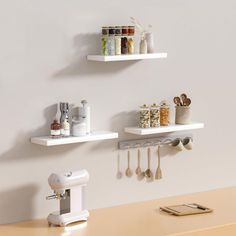 two white shelves with kitchen utensils on them