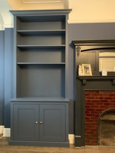 a living room with a fireplace and built in bookshelves