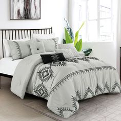 a bed with white and black comforters in a room