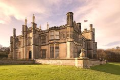 an old castle like building sitting on top of a lush green field