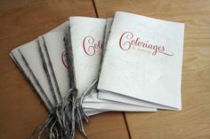 five white napkins with red lettering on them sitting on a wooden table next to a pair of scissors