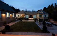 an outdoor patio area with lights on the side of it and landscaping in the front yard