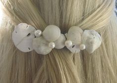 there is a hair clip with seashells and pearls on it's side