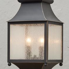 two lights are attached to the side of a light fixture with frosted glass panels