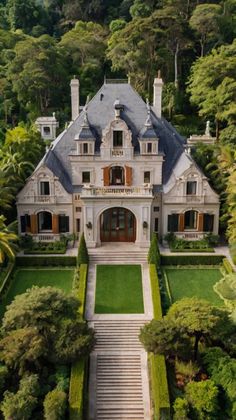 an aerial view of a large house in the middle of trees and bushes with stairs leading up to it