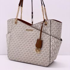 Brand New With Tag Michael Kors Large X Chain Shoulder Tote Bag Color: Vanilla 100% Authentic Guarantee! Details Shoulder Bag Logo-Print Canvas 89.4% Coated Canvas/9.6% Polyester/1% Polyurethane Gold-Tone Hardware 15.6"W 11"H 5.5"D Handle Drop: 10" Exterior Details: Front Slip Pocket Interior Details: Back Zip Pocket, 2 Back Slip Pockets Lining: 100% Polyester Zip Fastening Imported Michael Kors Shopping Bags With Chain Strap, Michael Kors White Shoulder Bag With Chain Strap, Michael Kors Brown Bag With Chain Strap, Michael Kors Bedford, Michael Kors Tote Bags, Large Leather Tote, Brown Tote, Bags Logo, Large Shoulder Bags