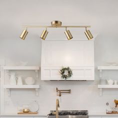 a kitchen with white cabinets and gold fixtures