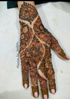 a henna on someone's hand with intricate designs