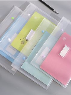 three different colored folders with a light switch on top of them and a pen next to it