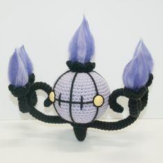 a crocheted crown with purple candles on it