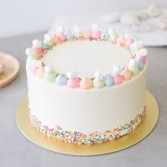 a white cake with sprinkles and colorful decorations