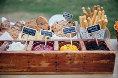 a wooden box filled with different types of food on top of a table next to other foods