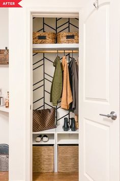 an open closet with baskets and coats hanging on the wall