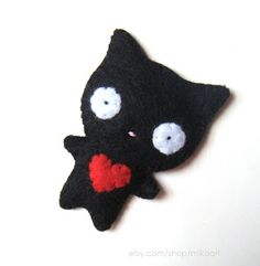 a black cat with a red heart on its nose