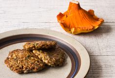 two patties on a plate next to an orange peel