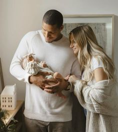 a man and woman holding a baby in their hands