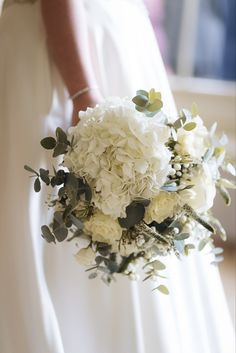 a bridal holding a bouquet of white flowers