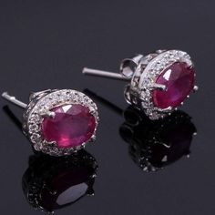 This Sterling Silver Earring features an Elegant Art With Natural Ruby Gemstone. The cavity is made from genuine solid 925/92.5 Sterling silver and stamped as S925. This Jewelry is Lead free. ITEM DESCRIPTION Item Code: JAER16 Metal: 925/92.5 Sterling Silver Gemstone: Natural Faceted Pink Ruby (Handcrafted) Gemstone Shape: Oval Gemstone Size: 6X8 MM Earring Length: 11 MM Earring width: 9 MM Surrounded Stones: Zircon Weight: 2.98 gm **Keep the jewelry away from direct heat, water, perfumes, deodo Sterling Silver Round Earrings With Halo Setting, Ruby Gemstone Earrings In White Gold, White Gold Ruby Gemstone Earrings, Classic Ruby Earrings With Halo Design, Ruby Round Earrings In White Gold, Stamped 925 Fine Jewelry Earrings For Anniversary, 925 Stamped Earrings For Anniversary, Classic Ruby Halo Earrings, White Gold Ruby Earrings With Prong Setting