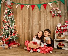 two children sitting on the floor with presents