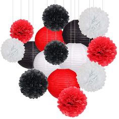 red, white and black paper lanterns hanging from strings with pom - poms