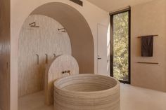 a large stone bathtub in a bathroom next to an open doorway with glass doors