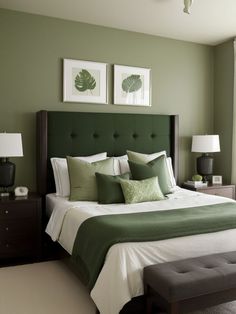 a bedroom with green walls and white bedding, two framed pictures on the wall