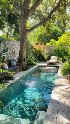 an outdoor pool surrounded by greenery and trees in the middle of a backyard area