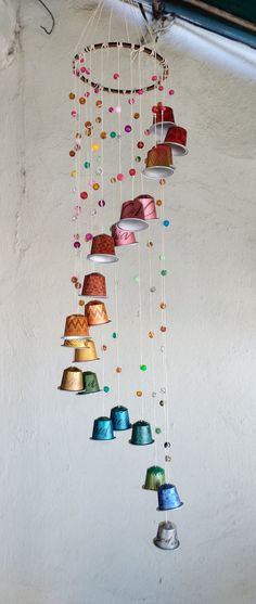 a wind chime with many different colored bells hanging from it's sides,