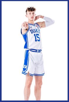 a young man in a basketball uniform is posing for a photo with his hand on his hip