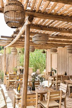 an outdoor dining area with wooden tables and chairs