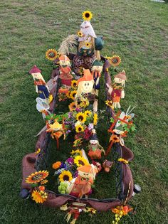 a wagon filled with lots of flowers and scarecrows sitting on top of a lush green field