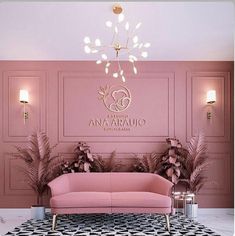 a pink couch sitting in front of a chandelier on top of a wall