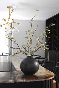 a vase filled with flowers sitting on top of a table next to a black chair